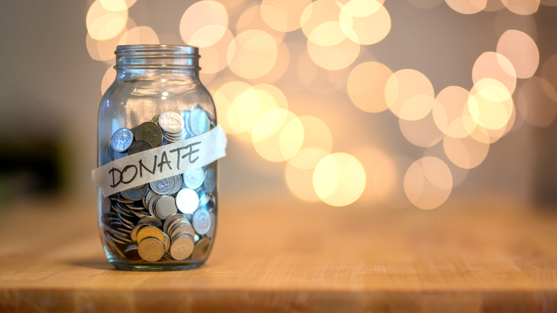 Glass jar with coins and the word donate paper label