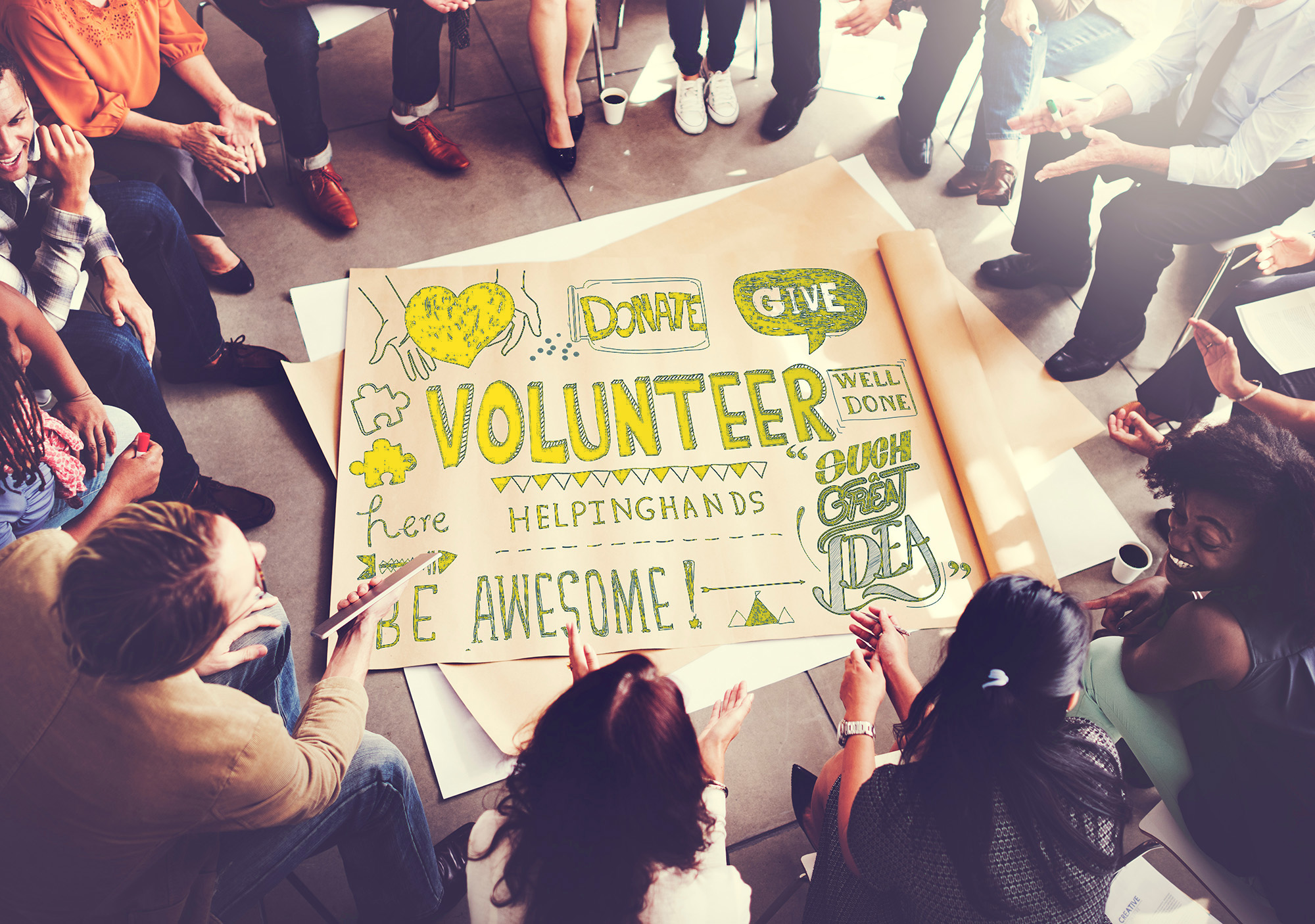 volunteers sitting around a volunteer sign